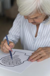 A senior woman engaging with an Alzheimer's puzzle at Cornerstone Senior Living in Boise, Idaho.